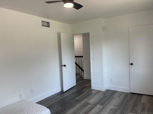 unfurnished bedroom with ceiling fan and dark hardwood / wood-style floors