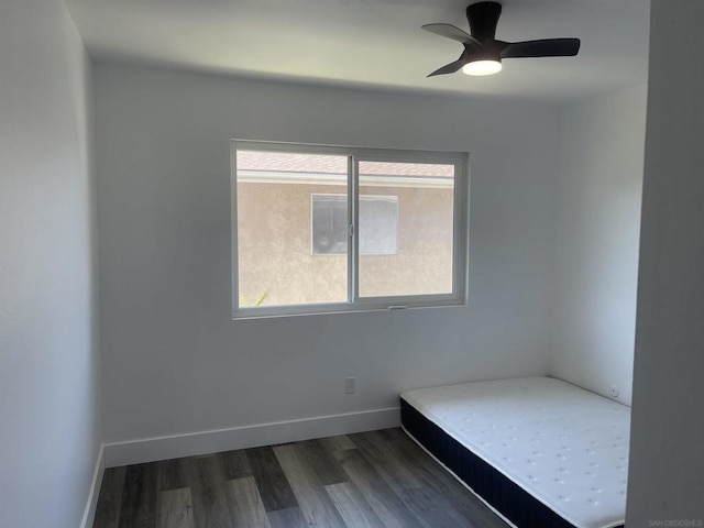 unfurnished bedroom featuring ceiling fan and dark wood-type flooring