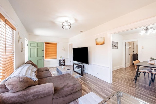 living room with an inviting chandelier and light hardwood / wood-style floors