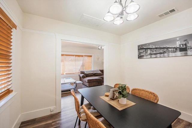 dining area featuring a chandelier and dark wood-type flooring