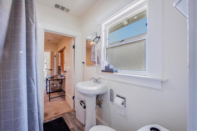 bathroom featuring a shower with curtain, wood-type flooring, and toilet