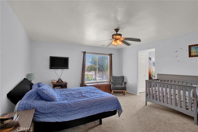 carpeted bedroom with a ceiling fan and a textured ceiling