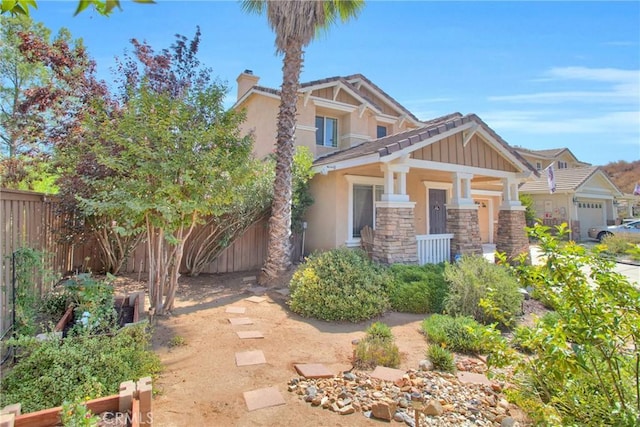 view of front of house featuring a chimney, fence, stucco siding, and stone siding