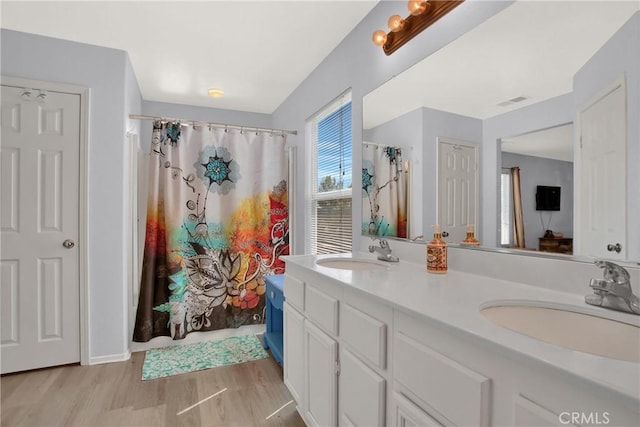 full bath featuring wood finished floors, double vanity, and a shower with curtain