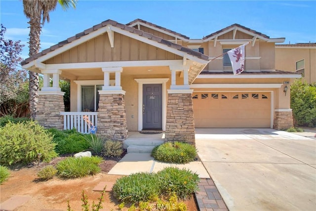craftsman-style home featuring an attached garage, stone siding, driveway, stucco siding, and a porch