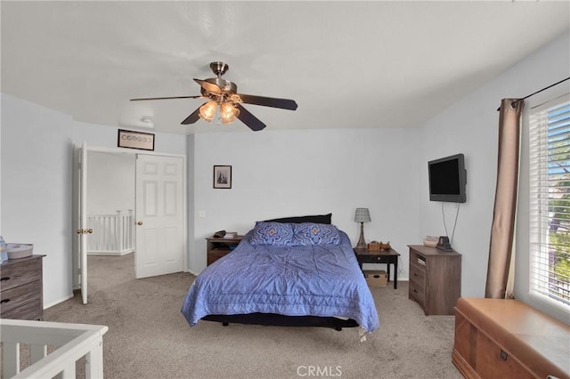 carpeted bedroom featuring multiple windows and ceiling fan