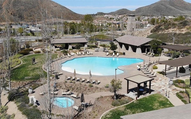 community pool with a patio area, a mountain view, a pergola, and a gazebo