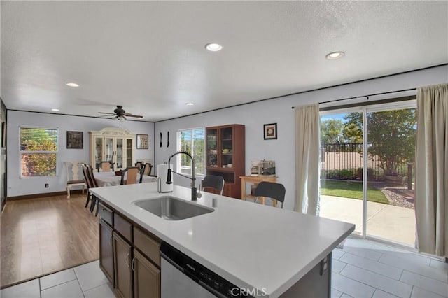 kitchen featuring a sink, healthy amount of natural light, light countertops, stainless steel dishwasher, and recessed lighting