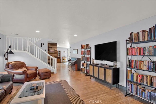living room with wood finished floors, stairway, and recessed lighting
