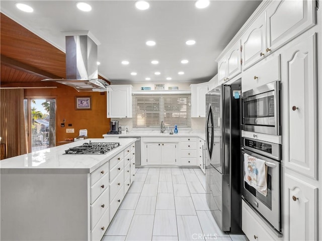 kitchen with a center island, white cabinets, sink, appliances with stainless steel finishes, and island exhaust hood