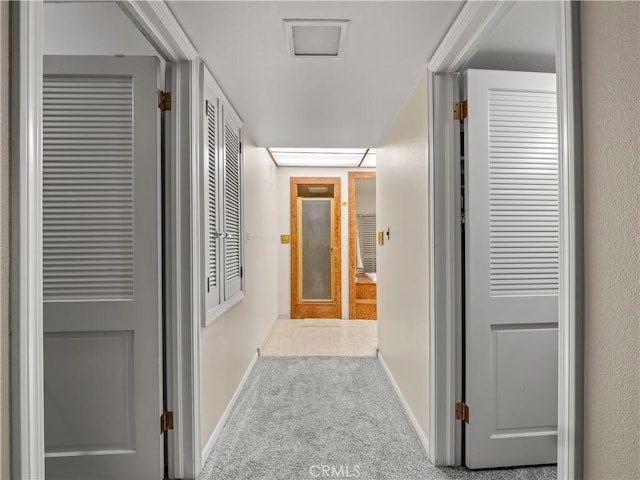 hallway featuring light colored carpet