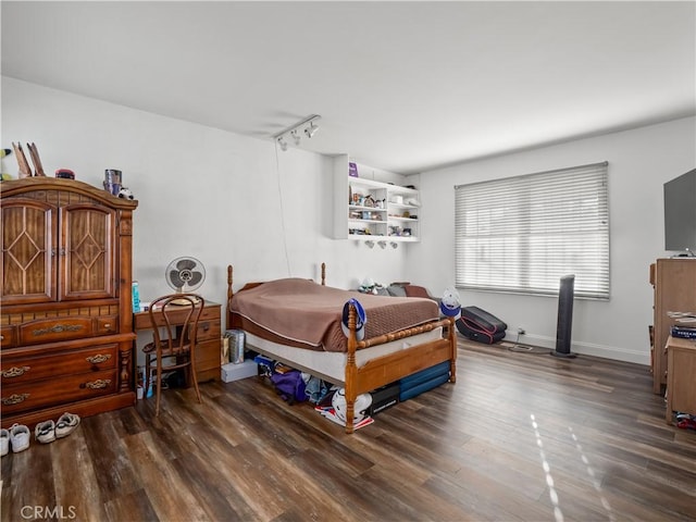 bedroom featuring dark hardwood / wood-style flooring and rail lighting