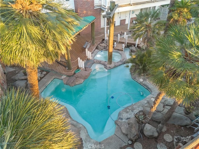 view of swimming pool with an in ground hot tub and a wooden deck