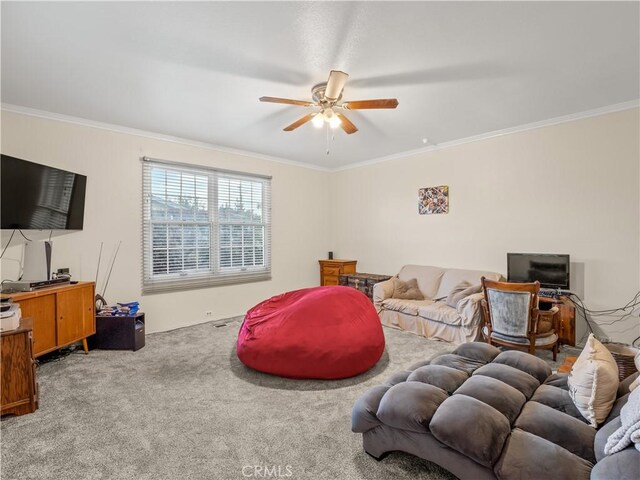 living room featuring carpet floors, ceiling fan, and crown molding