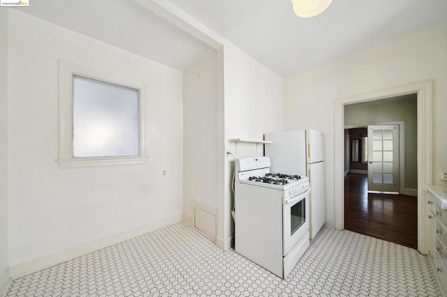 kitchen featuring white range with gas stovetop, light wood-type flooring, and white cabinetry