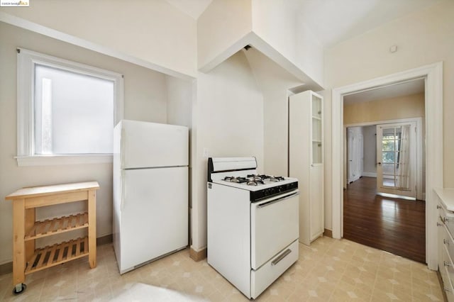 kitchen with light hardwood / wood-style floors, white appliances, and white cabinets