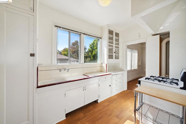 kitchen with white cabinets, hardwood / wood-style flooring, and plenty of natural light