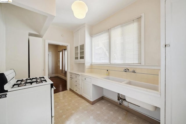 kitchen featuring white cabinetry and white range with gas stovetop