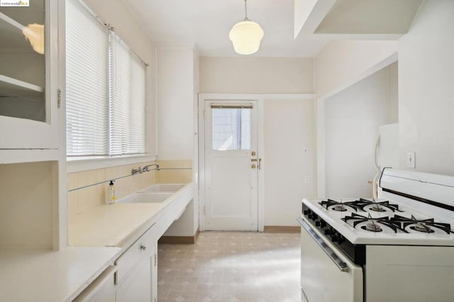 kitchen featuring decorative light fixtures, white appliances, and white cabinetry