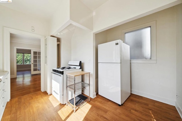 kitchen featuring light hardwood / wood-style floors, white appliances, and white cabinetry