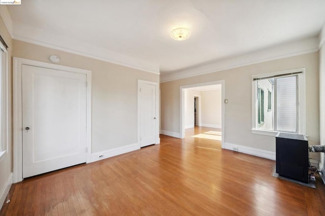 spare room featuring light hardwood / wood-style floors and crown molding