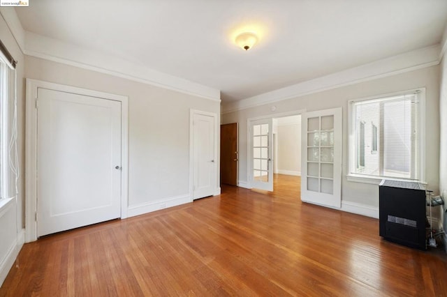 interior space with ornamental molding, hardwood / wood-style flooring, and french doors