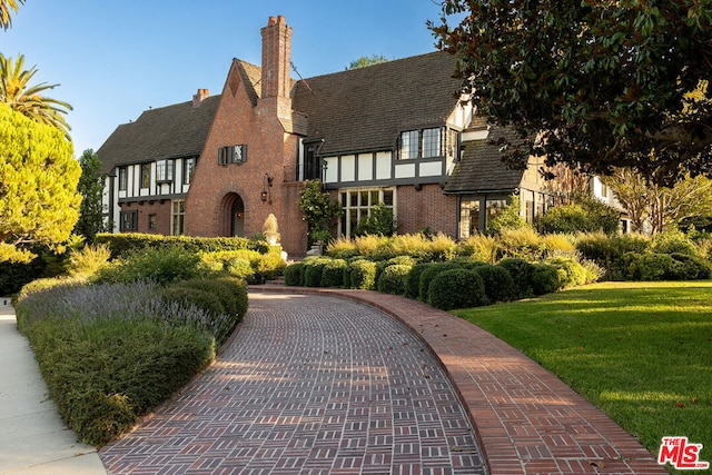 english style home with a front yard