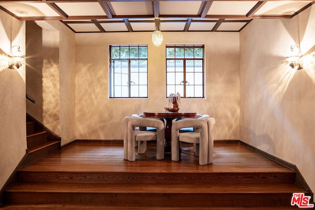 unfurnished dining area with coffered ceiling and hardwood / wood-style floors