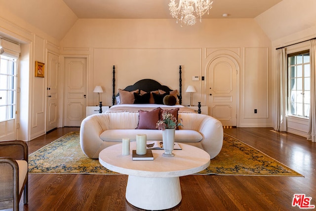 bedroom with dark hardwood / wood-style floors, vaulted ceiling, and a chandelier