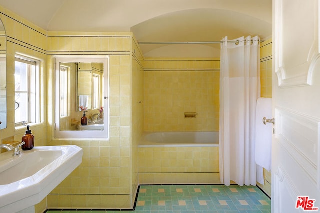 bathroom with lofted ceiling, shower / tub combo, and sink