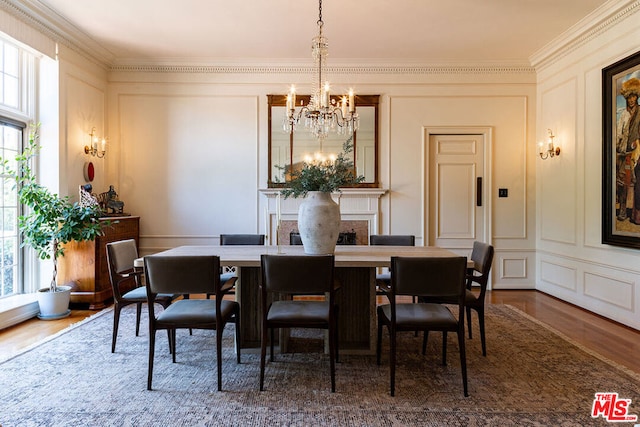 dining room with an inviting chandelier, crown molding, hardwood / wood-style floors, and a wealth of natural light