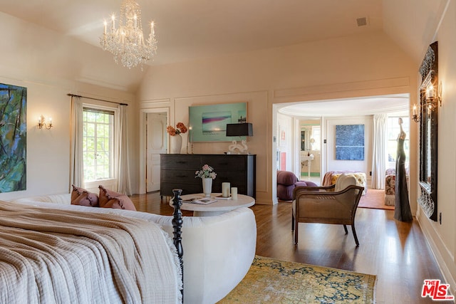 living room featuring a notable chandelier, lofted ceiling, and hardwood / wood-style floors