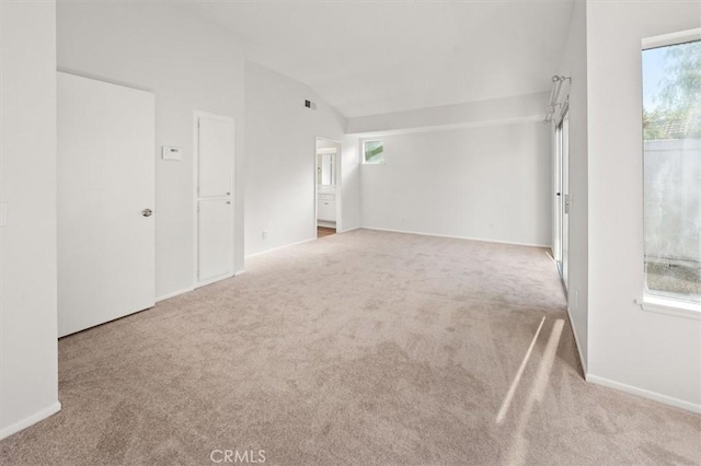 carpeted empty room with lofted ceiling