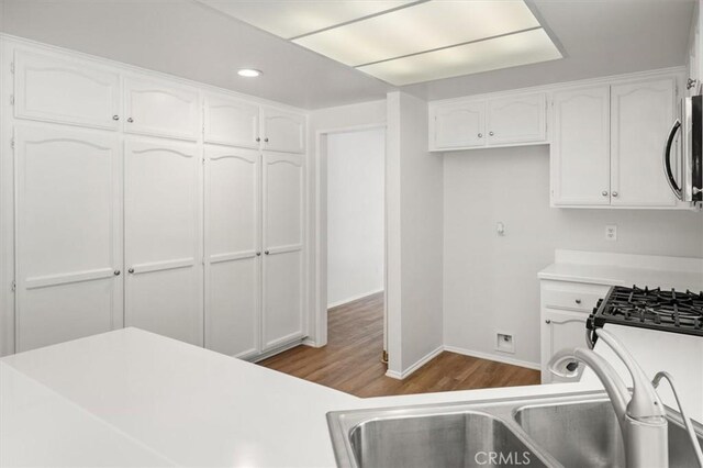 kitchen with sink, light hardwood / wood-style flooring, and white cabinets