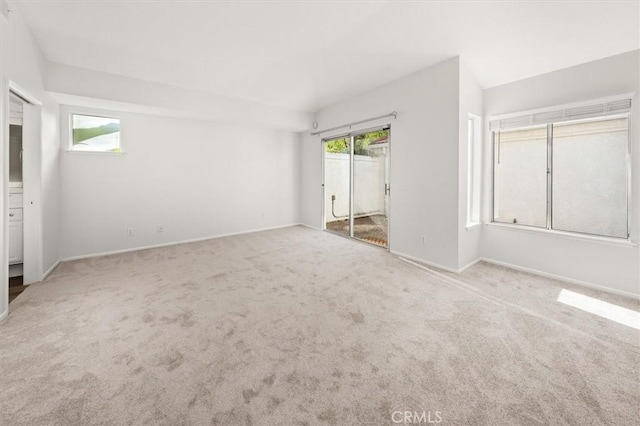 unfurnished bedroom featuring carpet flooring, multiple windows, and baseboards