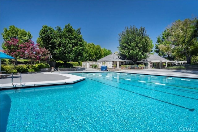 community pool featuring a patio and fence