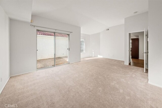 unfurnished bedroom featuring visible vents, carpet floors, and lofted ceiling