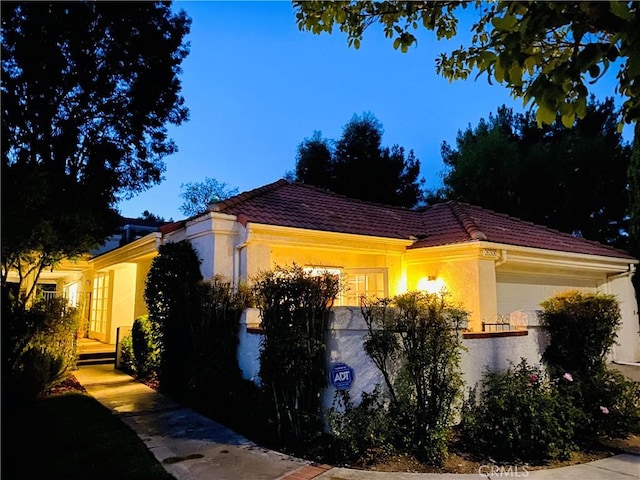 view of home's exterior featuring a tile roof and stucco siding