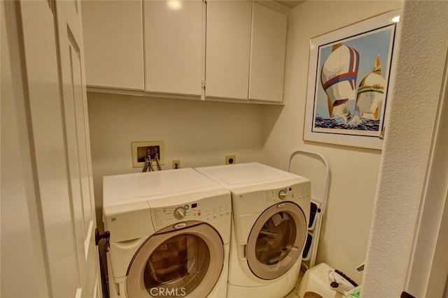 laundry room with separate washer and dryer and cabinets