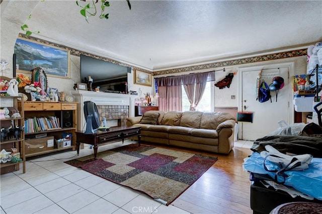 living room featuring a tile fireplace and light hardwood / wood-style flooring