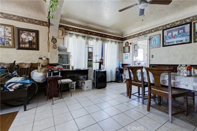 dining room featuring crown molding, light tile patterned floors, and ceiling fan