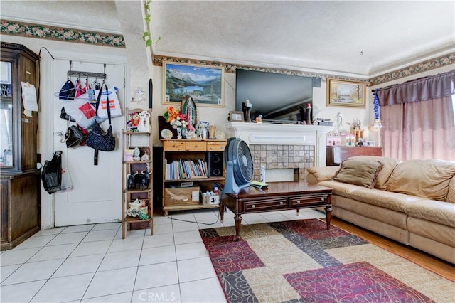 living room with light tile patterned flooring and a tile fireplace