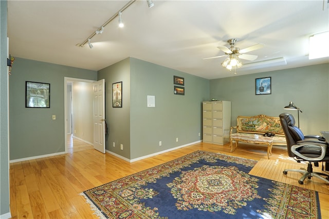 office featuring ceiling fan, rail lighting, and light hardwood / wood-style flooring