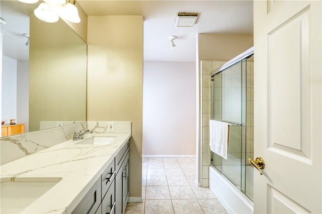 bathroom featuring tile patterned flooring, combined bath / shower with glass door, and vanity