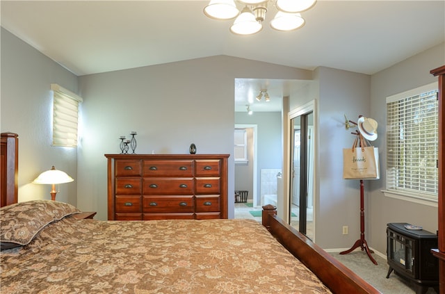 bedroom featuring carpet floors, vaulted ceiling, ensuite bathroom, and multiple windows