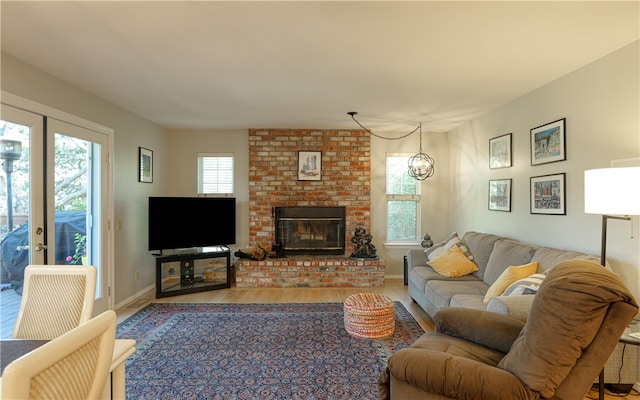 living room featuring a brick fireplace, hardwood / wood-style flooring, and french doors