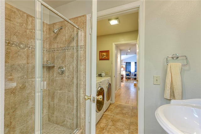 bathroom with washer and dryer, wood-type flooring, a shower with door, and sink