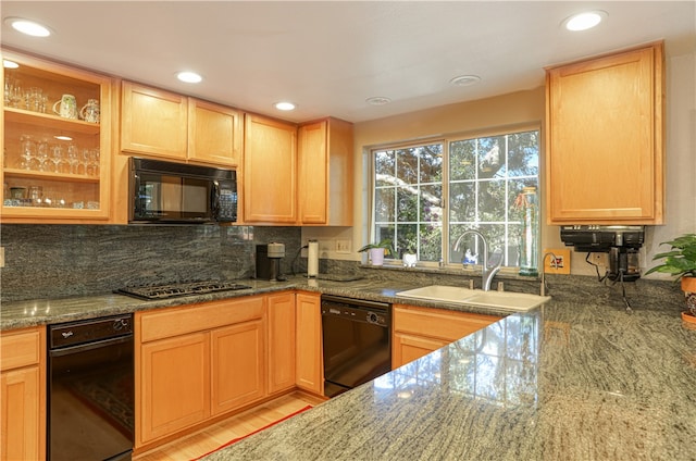 kitchen featuring black appliances, decorative backsplash, sink, light hardwood / wood-style flooring, and stone countertops