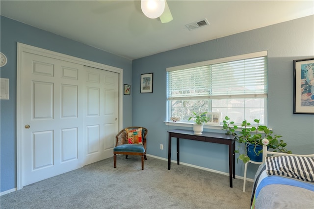 living area featuring light carpet and ceiling fan