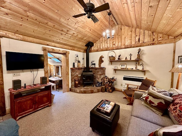 living room featuring vaulted ceiling, ceiling fan, wood ceiling, and a wood stove